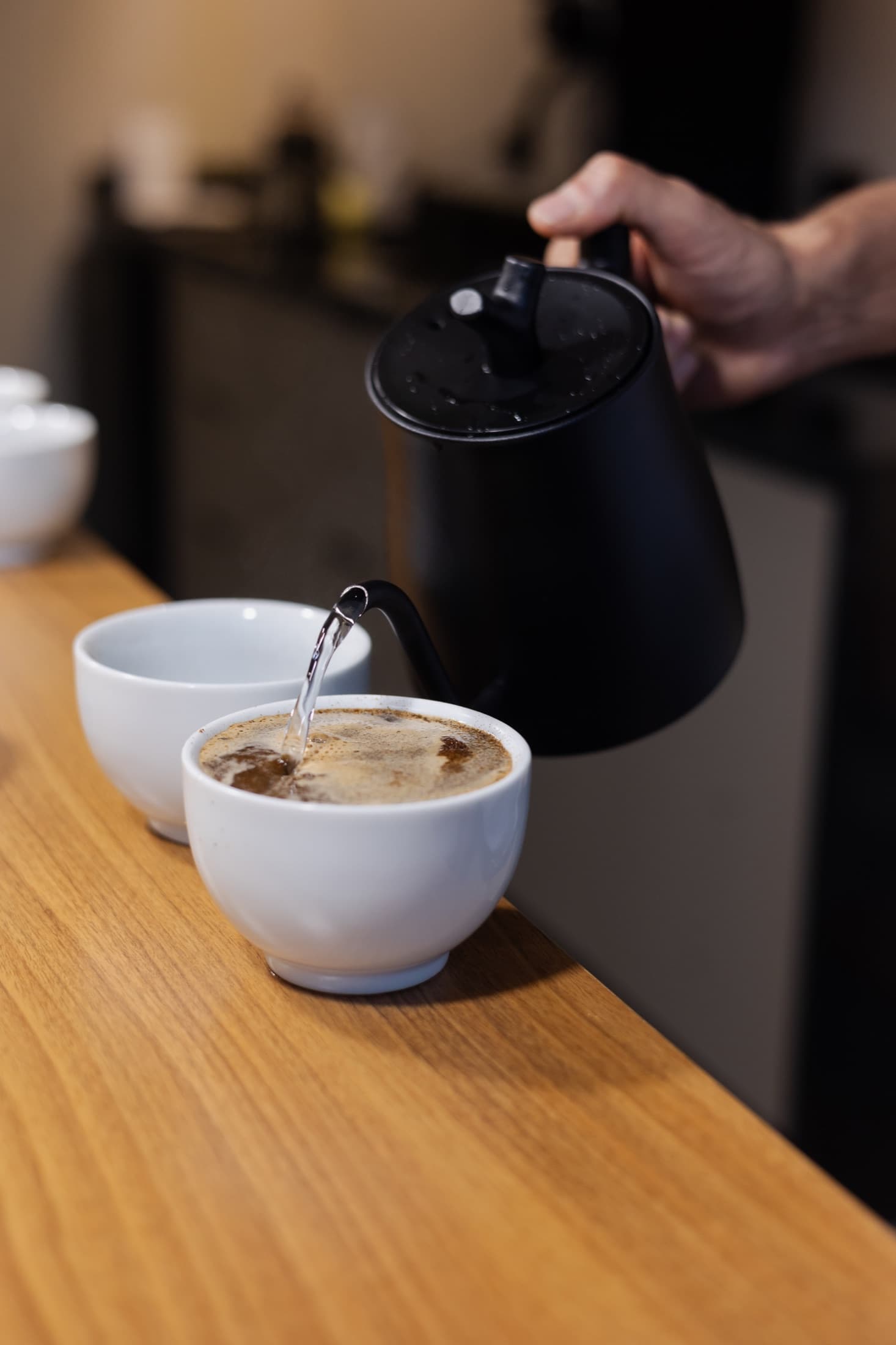 Água sendo adicionada às xícaras durante uma prova de café
